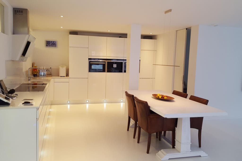 Moderne offene Küche mit Kaffeemaschine, Mikrowelle, Steamer, Backofen, Abwaschmaschine, Teppanyaki, Induktion Kochfelder, Sonos Soundsystem.
