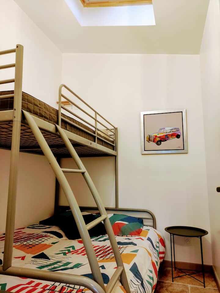 ห้องนอนที่มีเตียงคู่ที่ด้านล่างและเตียงเดี่ยวที่ด้านบนมีที่เก็บของด้วย 