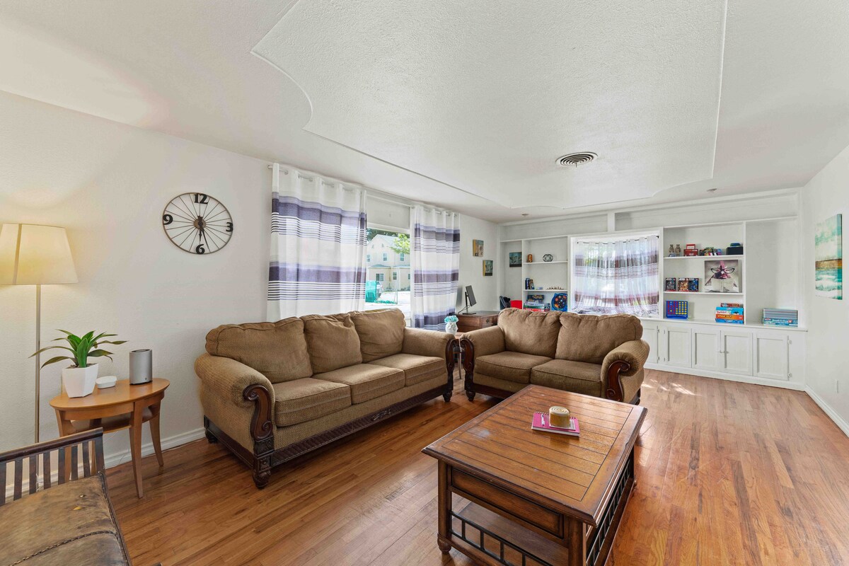 Dnevni boravak s jednim kaučem pune veličine i jednim dvosjedom. Tu je i klupa s lijeve strane, televizor s desne strane, a na krajnjoj lijevoj strani nalazi se radni stol s monitorom, tipkovnicom i mišem za povezivanje s prijenosnim računalom te zid pun igara.