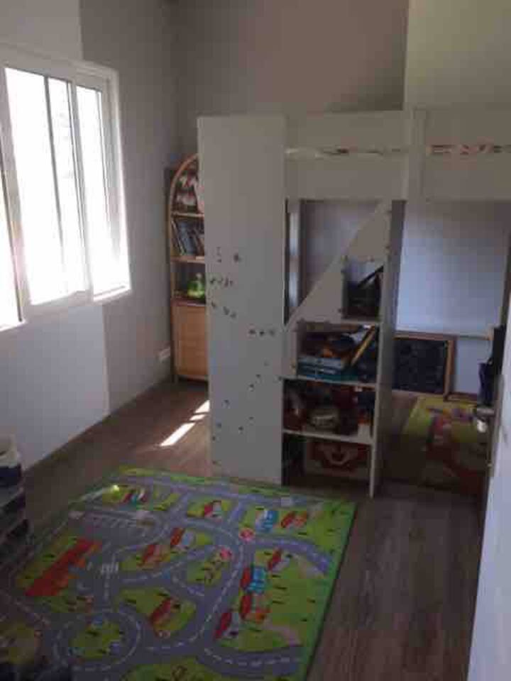 RDC, 11 m2, Chambre enfant lit simple haut avec palier et escalier intégré.