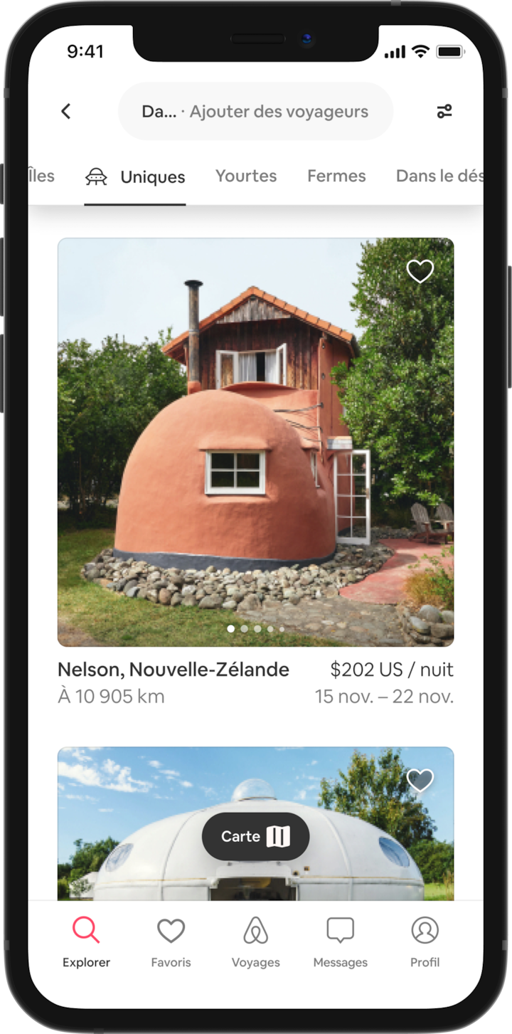 Un téléphone mobile affiche dans des onglets une sélection de lieux insolites où séjourner, tels que des îles, des yourtes, des fermes et bien plus encore. Les séjours affichés se trouvent dans la nouvelle catégorie « Atypique », et la première annonce est une maison en forme de botte.