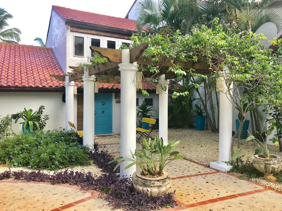 Villa entrance with pergola in front.