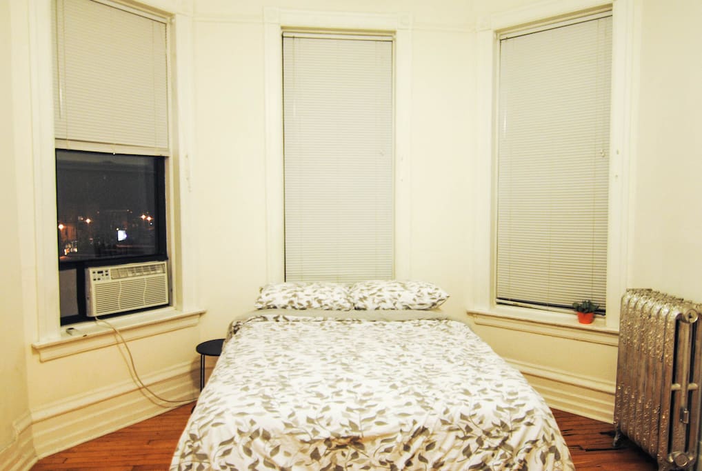 Cozy & minimalist bedroom w/ lots of natural sunlight & view of the John Hancock