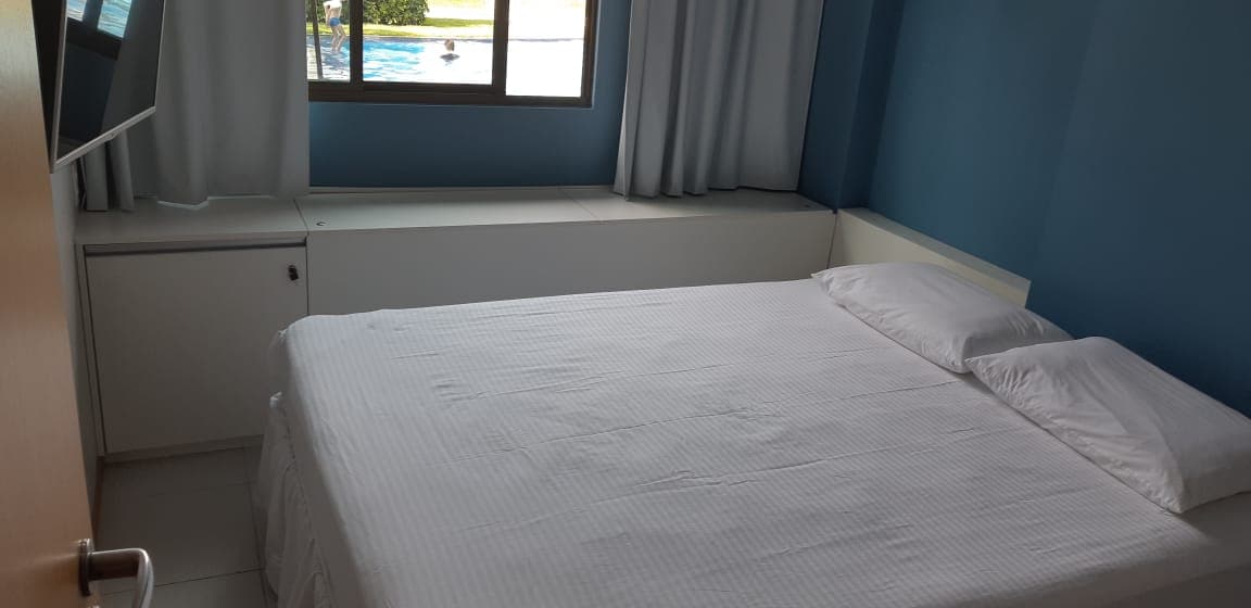 Chumba cha kulala cha kijamii kina kitanda cha ukubwa wa malkia, kitanda cha majira ya kuchipua na televisheni.