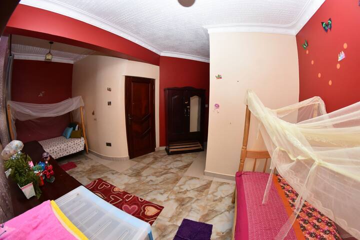 bedroom with 2 single beds, with wardrobe, chest drawers, toilet and shower.