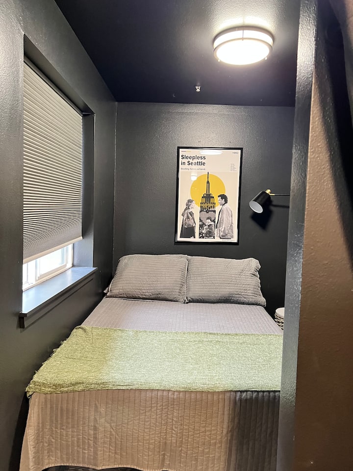 Rincón del dormitorio con cama de tamaño completo y televisión montada