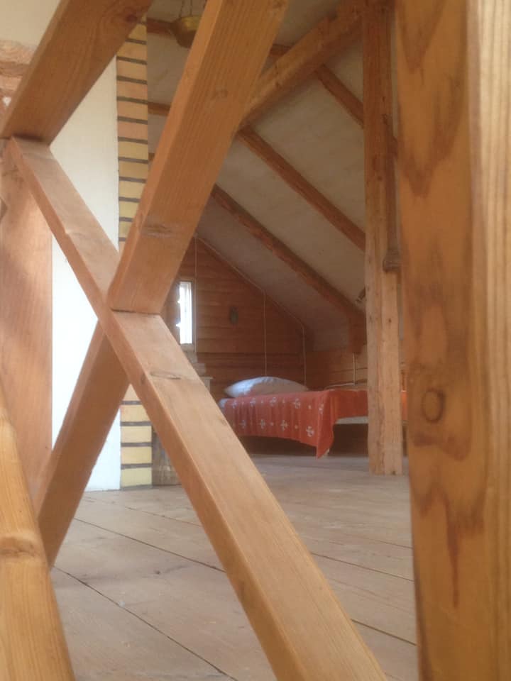Podkrovie. Na poschodí chaty je veľká izba s otvoreným kozubom, dvoma samostatnými lôžkami, detskou postieľkou s možnosťou hojdacej siete na spanie, ako aj jedálenský stôl a roh s kreslami. Priestor na spanie aj spoločenské stretnutie pri otvorenom ohni