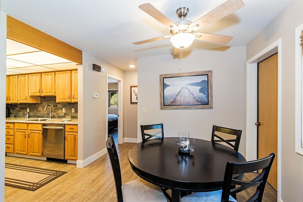 Enjoy a meal at this dining table, steps from the kitchen. The door to the right takes you down to the garage.
