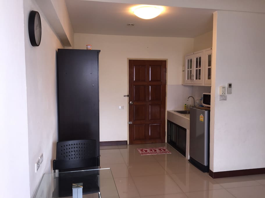 Main door with wardrobe on the left and pantry on right. Pantry has kettle, microwave and fridge.