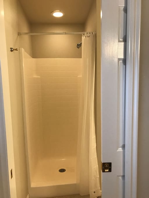 Stall shower with sliding door to bathroom.