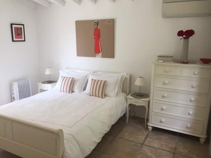 Bedroom 3 with French doors exiting to a private terrace with bistro table and chairs.