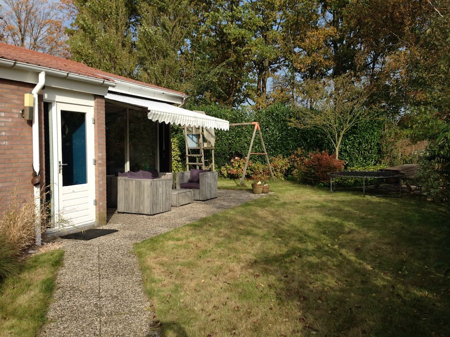 Ruime zonnige tuin met terras en aparte picknick-tafel