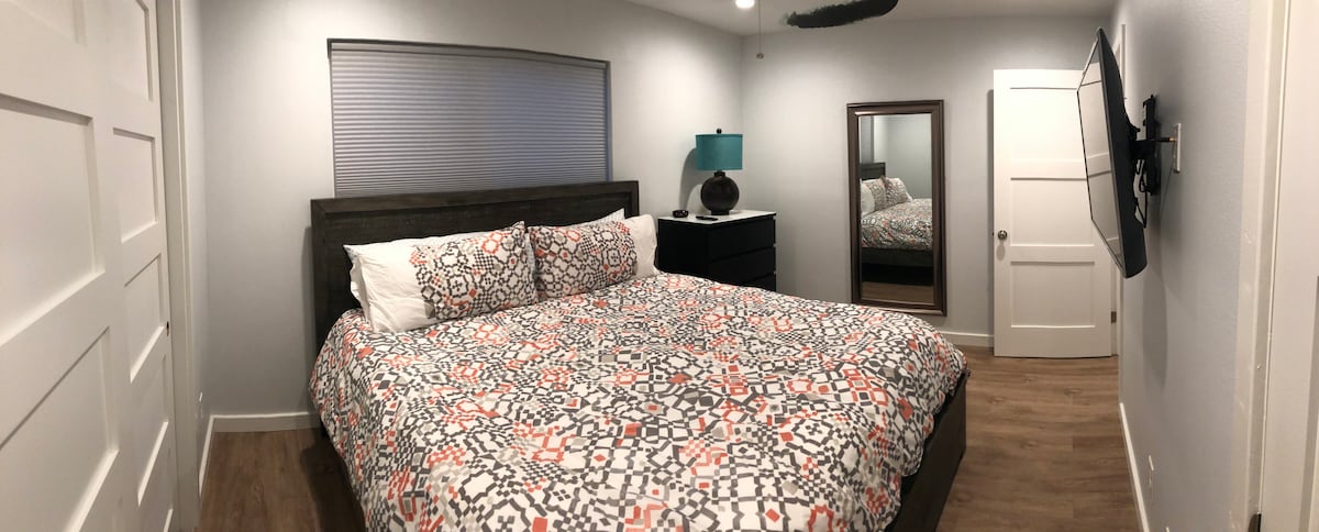 غرفة نوم ثانية بسرير كبير مع تلفزيون وحمام متصل