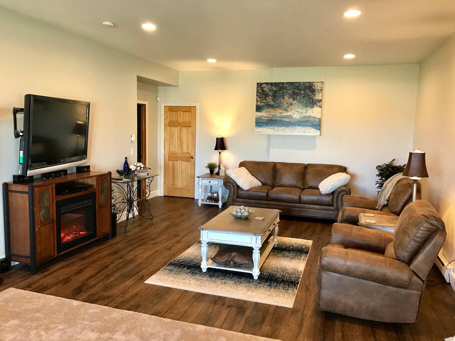 Living Room Space with Electric Fireplace, DVD Player and pull out queen sofa bed. Glass table for vanity or electronics. Photo 1
