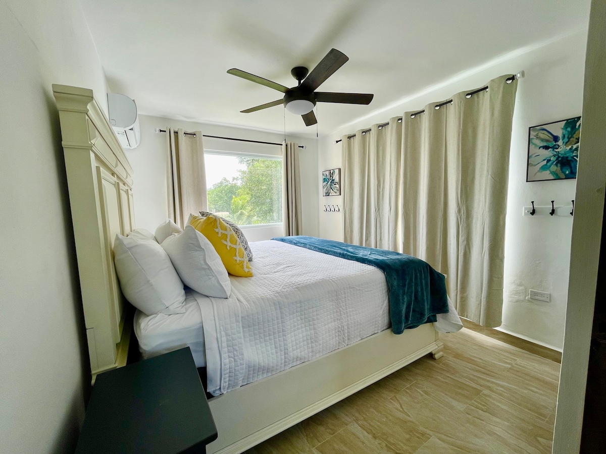 #5 Chumba cha kulala (ghorofa ya 2)

MWONEKANO WA BUSTANI
-- Kitanda aina ya King
- Kiyoyozi na feni ya dari. 
--Kuona bustani ya  uani iliyo na matunda ya mkate, avocado na miti ya ndizi
 