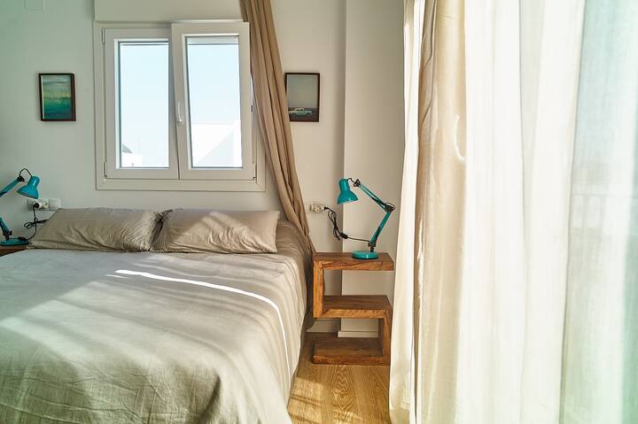 第三间卧室、配有双人床的主卧、阳台和套内卫生间。