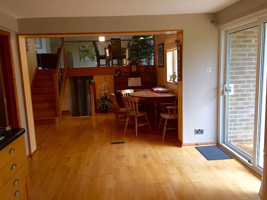Looking from kitchen to dinning room, with living room up the stairs and bedrooms down stairs. Sliding doors to right leading to decking and garden.