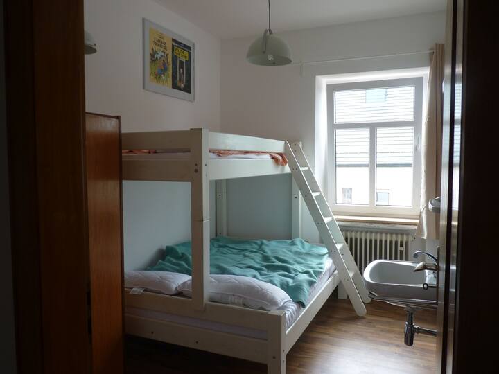 Schlafzimmer Hergé mit einem Etagenbett (unten 140x200cm, oben 90x200cm) und Waschbecken