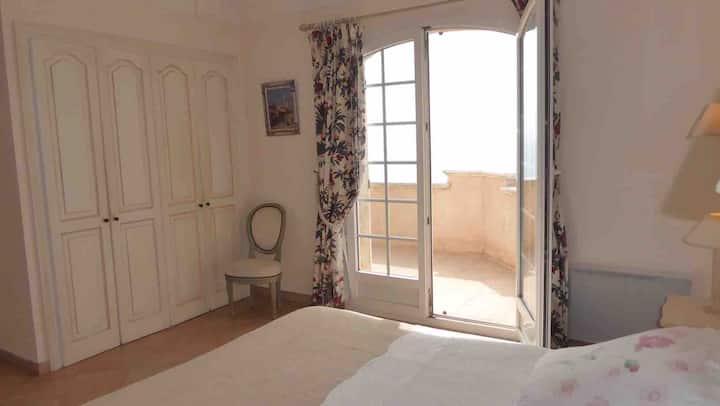 Chambre principale donnant sur la terrasse du haut et une très belle vue sur la mer
