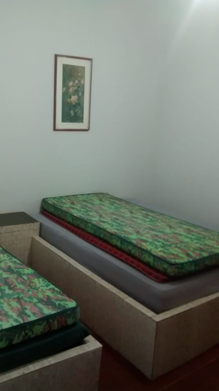 Izba pozostávajúca z jednej manželskej postele a jednej samostatnej postele. V tejto internáte je posteľ a kúpeľňa je vedľa nej .