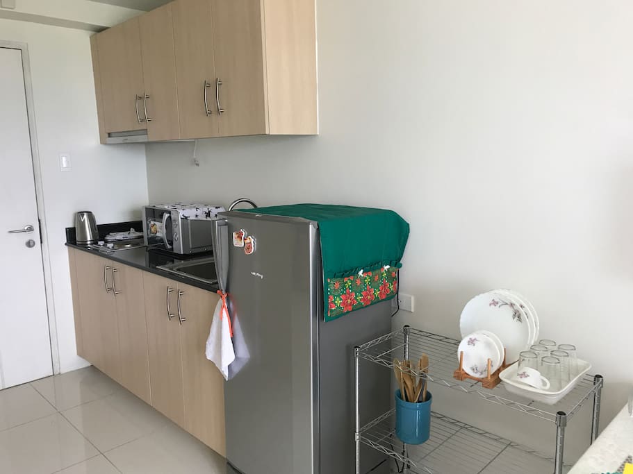 Kitchen with refrigerator, electric stove and microwave oven
