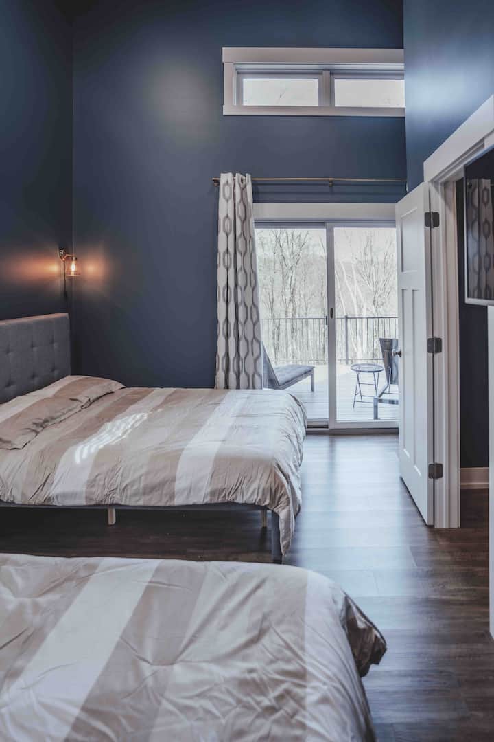 1 of 2 bedrooms on the upper level with super cozy Queen and Full bed, satellite TV, and quick access to the upper deck with panoramic views.