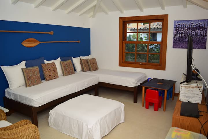 غرفة تلفزيون مع حمام ومروحة ومكيف هواء مقسم للمتعة العائلية.