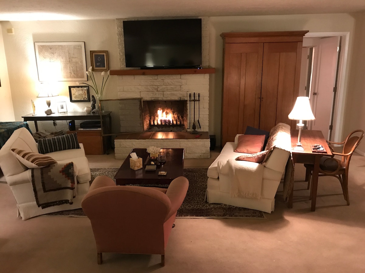 Západný koniec obývacej izby s kozubom a káblovou  TV.