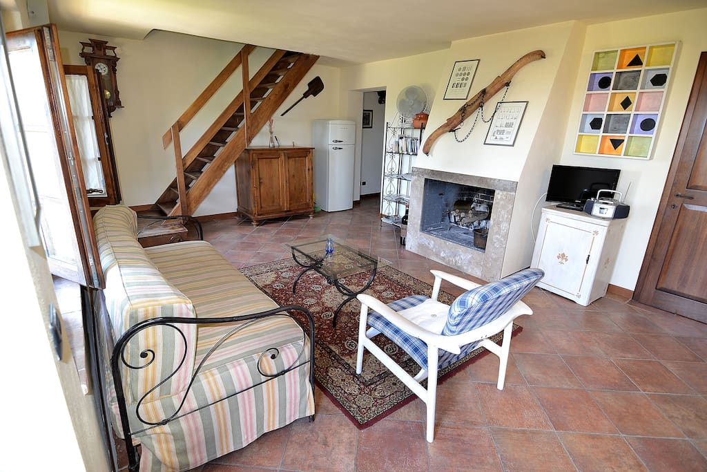 Spacious Living Room with Fireplace entering in the apartment. The Apartment is setting on the 1t Floor of the Farm House