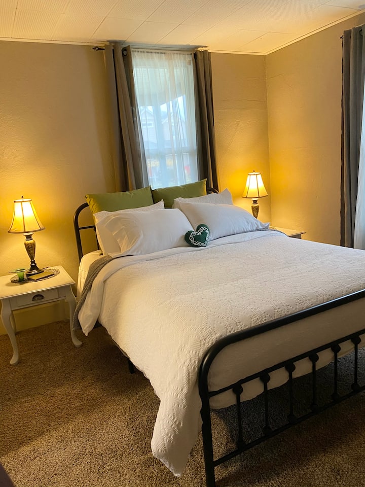 سرير بحجم كوين مع ملاءات مريحة ووسائد ومراتب جديدة. 