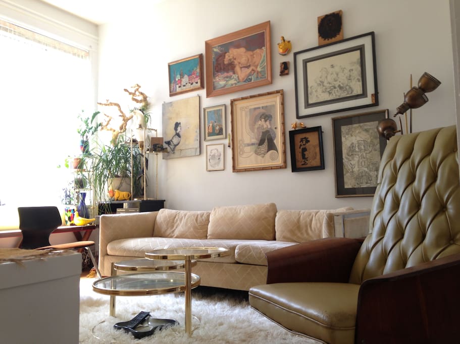 The living room is bright, sunny, and full of art.