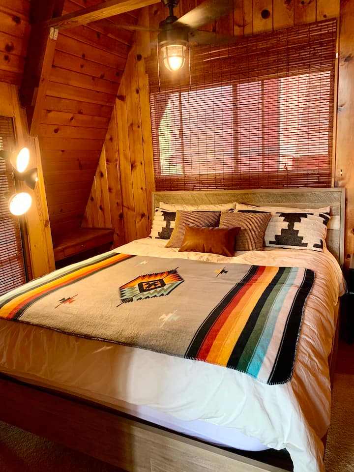 Disfruta de una buena noche de descanso en esta gran cama tamaño king California ubicada en el loft del tercer piso.
