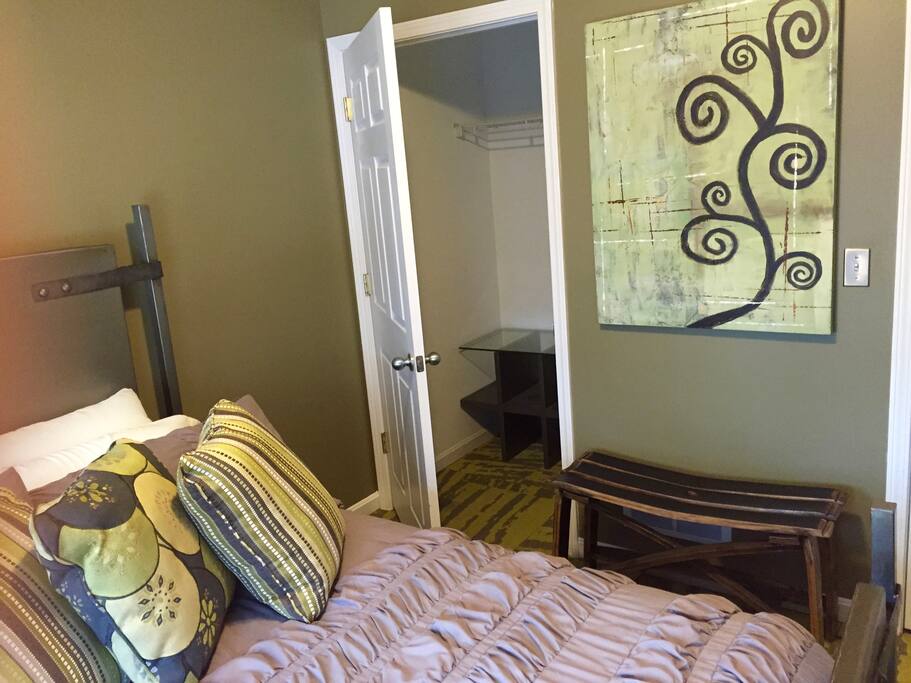 Large closet includes iron and ironic board, hangers and luggage table.