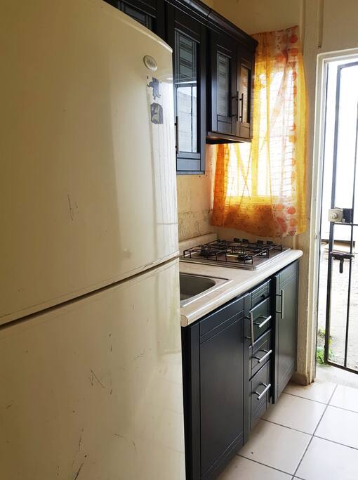 Cocina con estufa, refrigerador, utensilios de cocina para cuatro personas