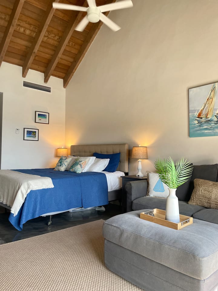 Dormitorio principal en la planta superior con baño privado, techos de catedral, colchón de espuma viscoelástica tamaño king y sofá cama tamaño queen adicional con balcón privado en el piso superior.