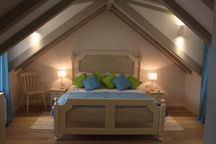 V hornej spálni je super-king-size posteľ a nádherný výhľad na záliv na jednu stranu a výhľad na terasu pri bazéne na druhej strane.