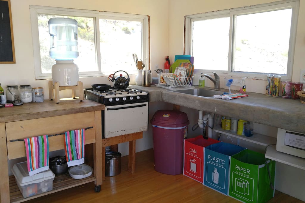 Small kitchen has propane oven & range, microwave, mini-fridge, and cold running water.