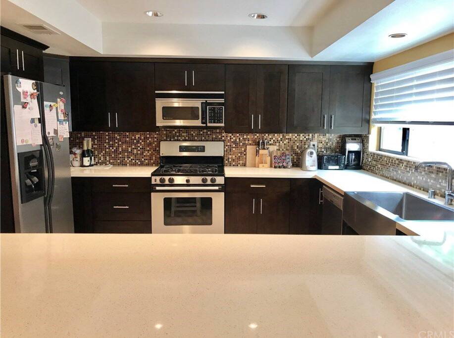 Your eyes will delight in the lavishly appointed gourmet kitchen complete with stainless steel appliances including refrigerator, rich cabinetry, farmhouse sink, quartz countertops, glass tile backsplash & recessed lighting.