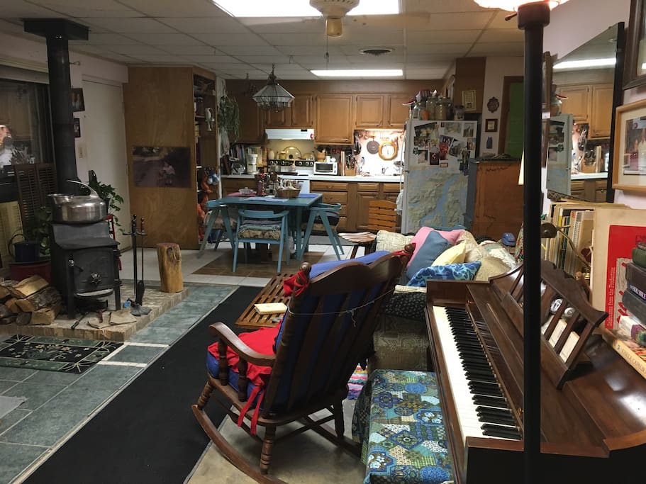 View of main open room. The wood stove keeps it toasty warm in winter. Feel free to indulge your creativity on the piano.