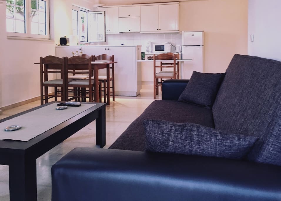 The cosy Living room with doors opening out onto the large patio. There is comfortable sofa, TV, wifi, air conditioning