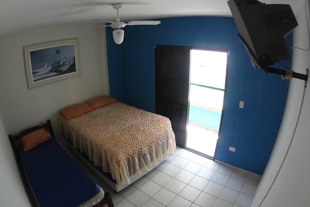 Quarto com sacada, vista lateral do mar, uma cama de casal, uma cama de solteiro, dois colchões avulsos de casal, um colchão avulso de solteiros.