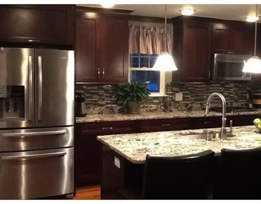 Gourmet kitchen with stainless steel round. Access to refrigerator, dishwasher, microwave, stove and double oven.