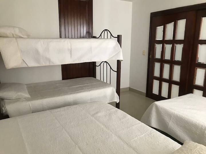 Chambre 1. 
Deux lits simples et un lit superposé, TV, placard, climatisation.