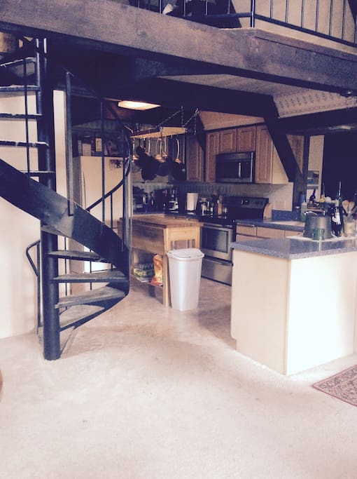 Kitchen with spiral staircase that leads to loft bedroom