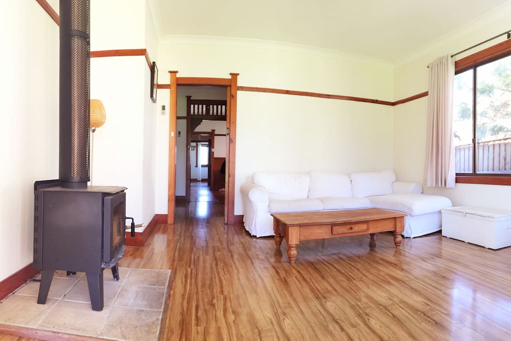 Light filled lounge room with wood fire.