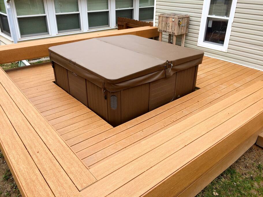 Newly built composite deck and bench surrounding the hot tub.