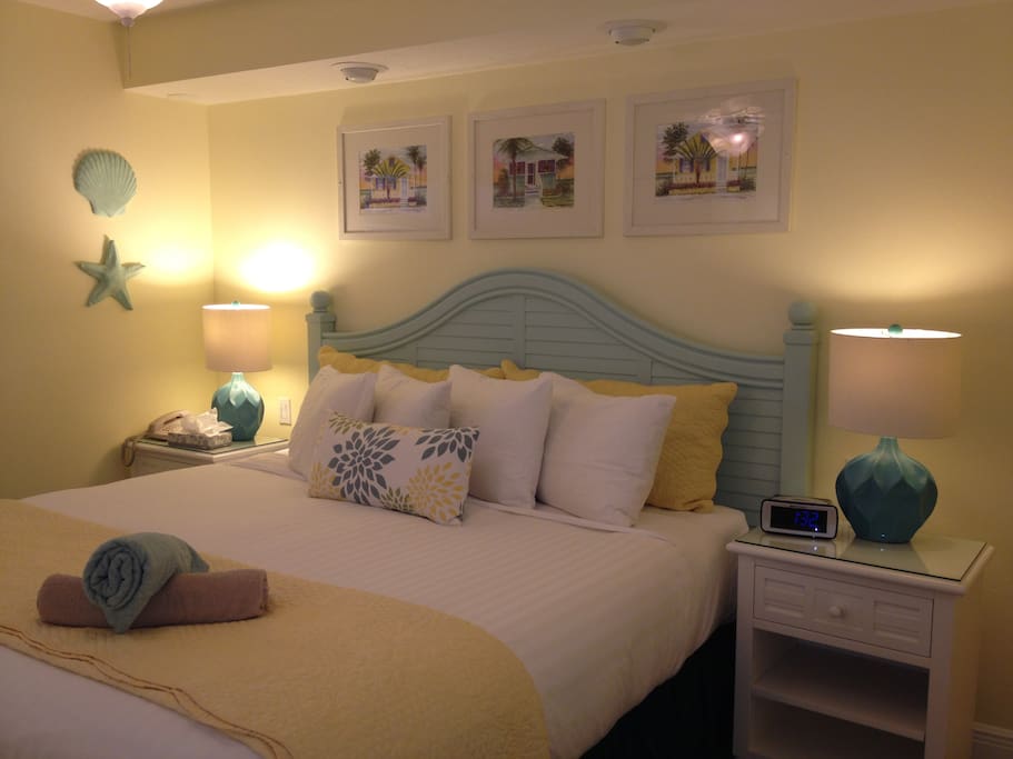 King size bed with crisp 400 Thread Count Linens, Down Pillows and Comforters.