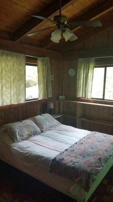 Private guest room has queen bed, shelves, closet
