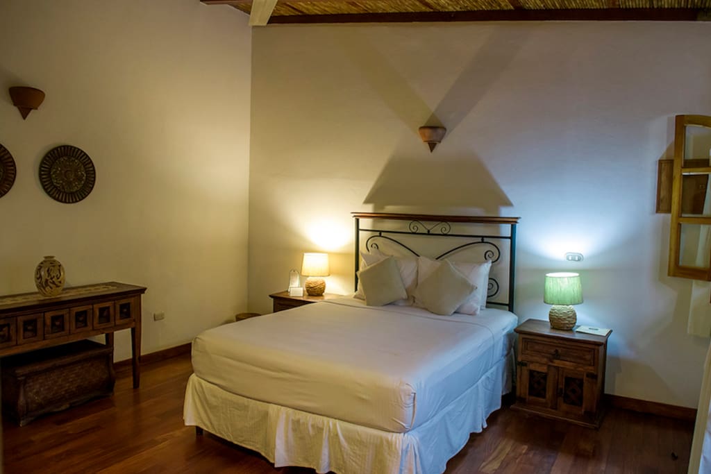Bedroom with handmade furniture, night tables, wi-fi and ceiling fan.