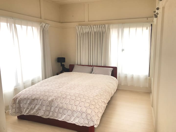 2階のメインゲストルーム（ダブルベッド）。ミラー＆チェアー、クローゼット、ソファーあり。エアコン完備